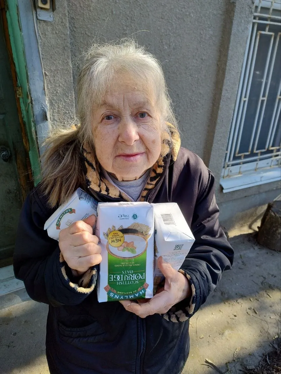 Літня жінка отримує продукти харчування